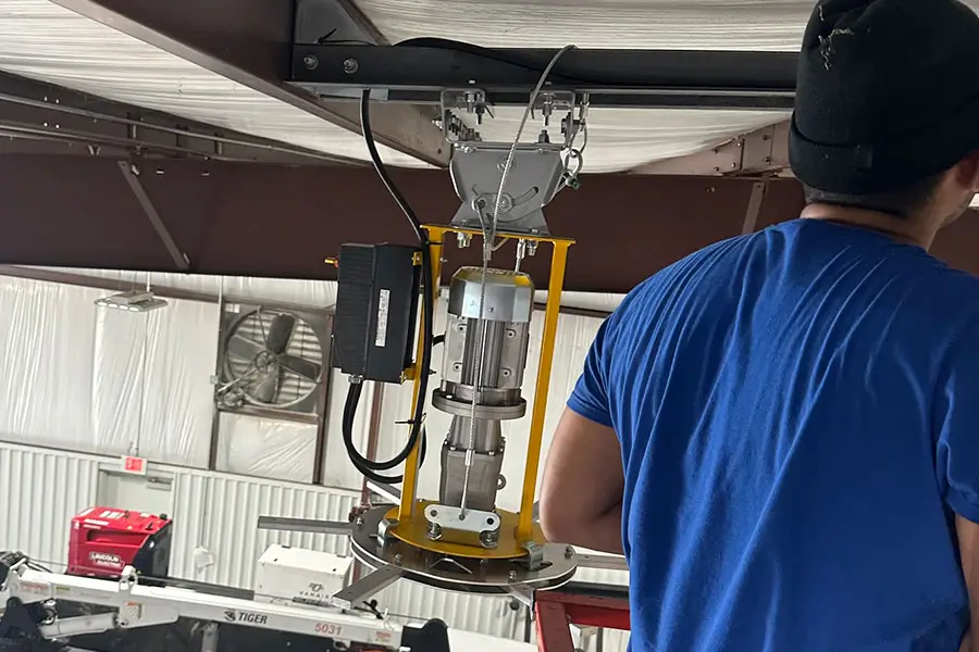 Commercial electrician servicing overhead equipment indoors