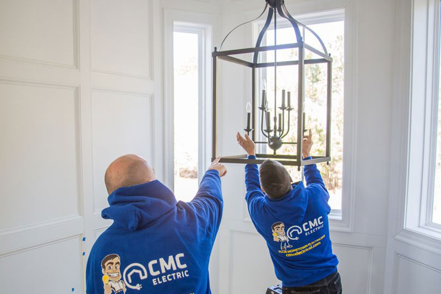 CMC Electric technicians installing indoor chandelier