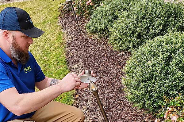 CMC Electric technician adjusting outdoor landscape lighting